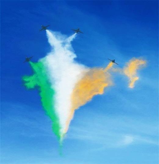 Aircraft drawing an outline in coloured smoke against a clear blue sky