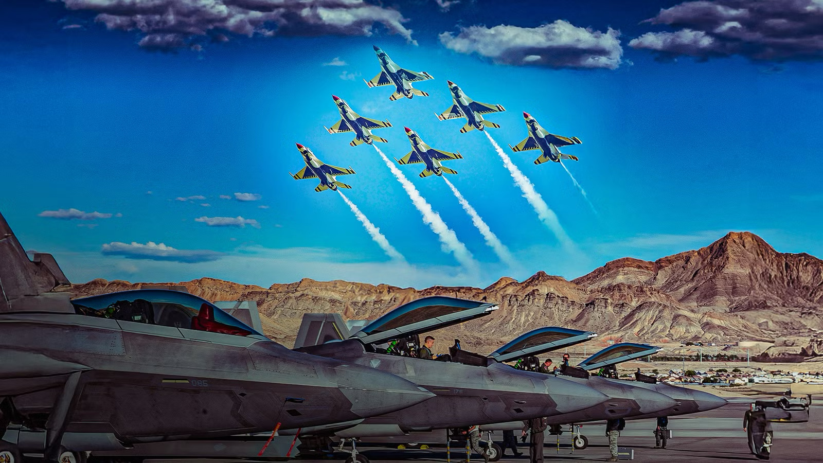 Ground crew and aircraft on a flight line with a formation of jets passing overhead